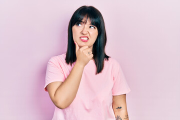 Young hispanic woman wearing casual clothes thinking worried about a question, concerned and nervous with hand on chin