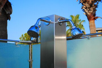 Closeup of outdoor shower heads. Outdoor poolside shower column.