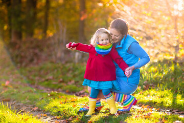 Mother and kids in autumn park. Family in rain.