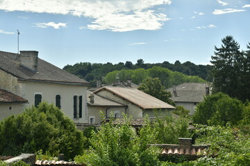 Fototapeta na wymiar Les toits des maisons et la colline boisée au Bourg de Champagne au Périgord Vert