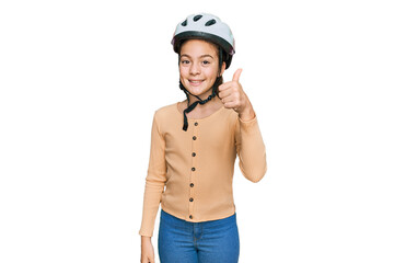 Beautiful brunette little girl wearing bike helmet smiling happy and positive, thumb up doing excellent and approval sign