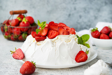 Pavlova cake with meringue and fresh strawberries on a light background, selective focus