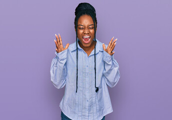 Young african american woman wearing casual clothes celebrating mad and crazy for success with arms...