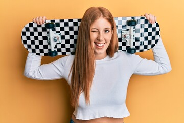 Young irish woman holding skate winking looking at the camera with sexy expression, cheerful and...