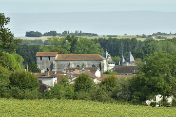 L'&eacute;glise en style romane et les tourelles du ch&acirc;teau au Bourg de Champagne au P&eacute;rigord Vert
