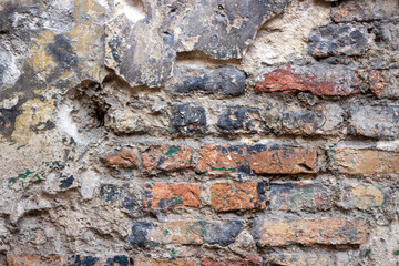 Old brick wall with peel stucco texture. Retro vintage worn wall background. Decayed cracked rough abstract wall surface