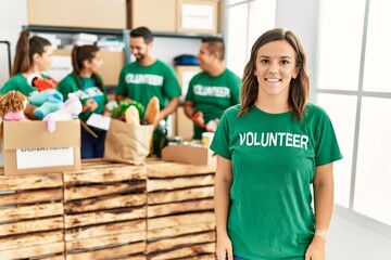 Group of young volunteers smiling happy working at charity center.
