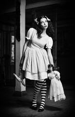 Strange girl with dolls in hands. Black and white
