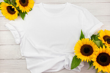 White womens cotton T Shirt mockup with sunflowers on white wooden background. Design t shirt...