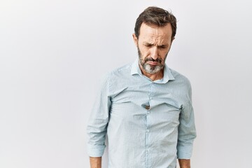 Middle age hispanic man with beard standing over isolated background depressed and worry for...