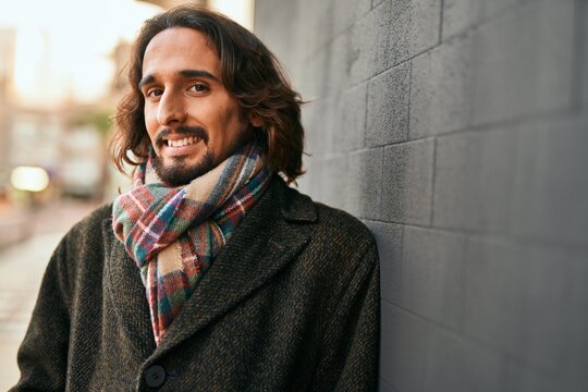 Young hispanic man smiling happy standing at the city.