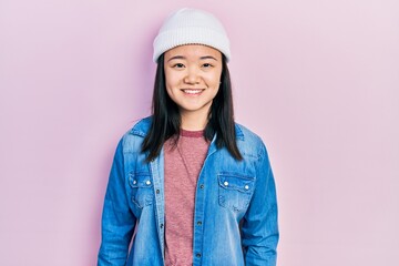 Young chinese girl wearing cute wool cap looking positive and happy standing and smiling with a confident smile showing teeth