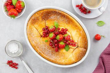 Homemade casserole with cottage cheese, semolina, fresh red currant and strawberry on light gray...