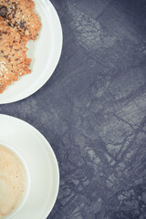 Cup of coffee with milk and fresh baked oatmeal cookies with honey and healthy seeds. Delicious crunchy dessert. Copy space for text