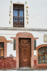 Fototapeta na wymiar Singula facade with ancient wooden door in Santo Domingo de la Calzada, La Rioja, Spain, Europe