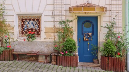 The front view of the blue entrance door decorated with flowers