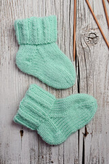 Fototapeta na wymiar Mint color small newborn socks made of soft cotton yarn