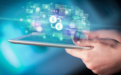 Close-up of a hand using tablet, currency concept