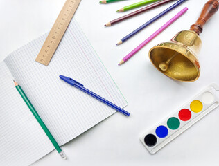 School life. School bell. Stationery on white background