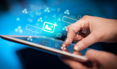 Close-up of a hand using tablet, social media concept