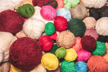 Ovillos de lana de diferentes colores y tamaños  sobre un fondo de madera. Crochet, ganchillo. Bolas de hilo. Madejas. - obrazy, fototapety, plakaty