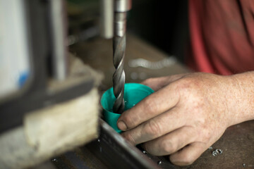 Cooling drill on a drilling machine. Work with a drill in a metal workshop.