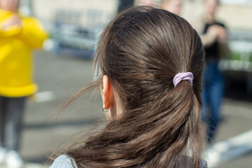 Hair on the head. The girl's hair. Hair gathered in a ponytail.