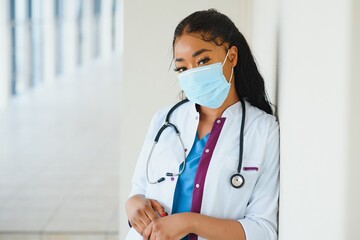 medicine, profession and healthcare concept - african american female doctor or scientist in protective facial mask in clinic