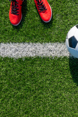 Soccer football background. Soccer ball and pair of football sports shoes on artificial turf soccer...