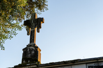 strange cross in a cemetery at sunset