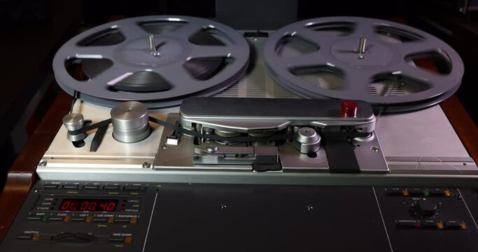 Front tracking shot on a vintage professional tape recorder while operating