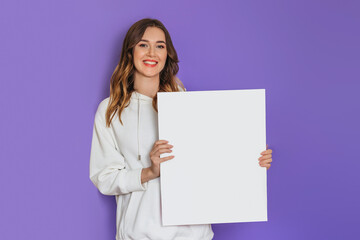 Young caucasian student girl holding a white sheet of paper, poster, placard in hands smiling isolated on lilac background