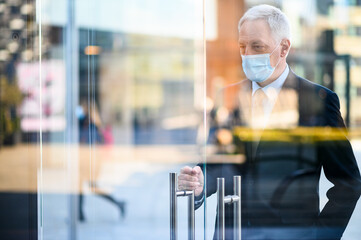 Senior manager opening the door to enter a modern office