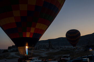 Obraz premium Launching balloons, preparing for departure and receiving tourists on board. Early morning Sunrise in Cappadocia, Turkey