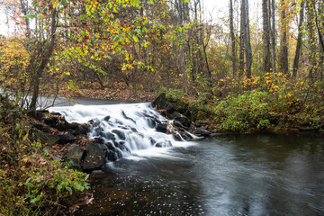 Obraz na płótnie Canvas Refreshing Waterfall Hidden Deep in the Autumn Forest