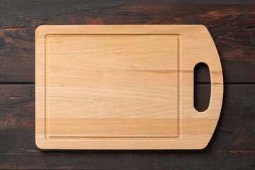 New rectangular bamboo wooden cutting board on wooden table. Top view. Mock up for food project.