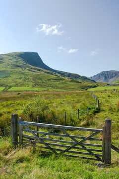 Snowdonia national park, Wales. Dramatic mountain landscape. Farm gate in the foreground with Y Garn mountain in the distance. Blue sky and copy space.