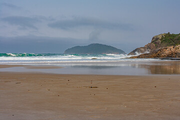 Praia com montanhas e ondas, Florianópolis, Brasil
