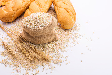 Delicious organic bread with wheat ears and wheat grains There is space to copy text. On a white table top in a rustic kitchen - top view