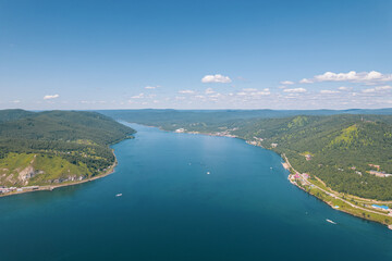 Obraz premium The Angara River in Siberia leaving Lake Baikal near the settlement of Listvyanka. Panoramic aerial view.