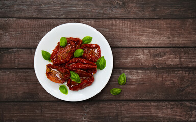 Sun dried tomatoes with fresh green basil leaves