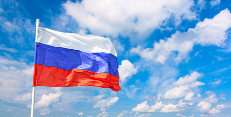 Waving russian flag against blue cloudy sky background