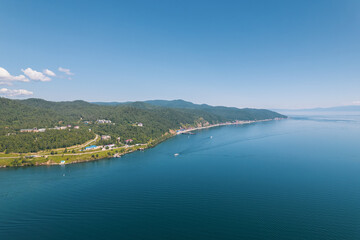 Lake Baikal is a marvelous blue jewel framed by scenic mountains and forests. Epic cinematic aerial view Lake Baikal. Aerial view of blue lake and green forests.