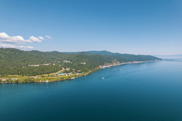 Fototapeta na wymiar Lake Baikal is a marvelous blue jewel framed by scenic mountains and forests. Epic cinematic aerial view Lake Baikal. Aerial view of blue lake and green forests.
