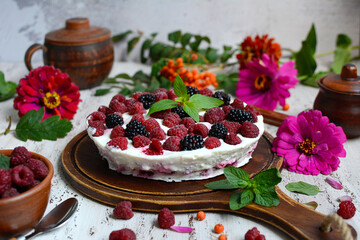 Mousse curd cake with raspberries without baked on a light background with flowers