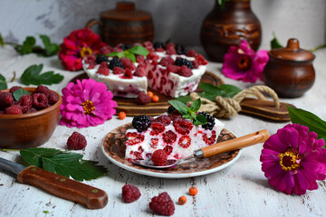 Beautiful summer still life. Appetizing pie with cottage cheese and raspberries, flowers, a ceramic bowl with raspberries on a light background. Seasonal berries and baked goods