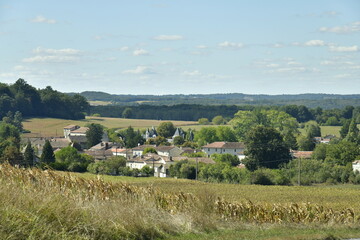 Le Bourg de Champagne entre prairies et bois vu depuis la route menant au Puy de Versac au Périgord Vert