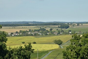 Fototapeta na wymiar Le bourg de Fontaine entre champs et bois vu depuis le Puy de Versac au Périgord Vert