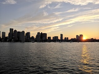 Fototapeta na wymiar Colorful sunset over Boston skyline from the sea