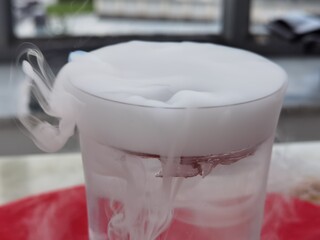 glass with overflowing white haze